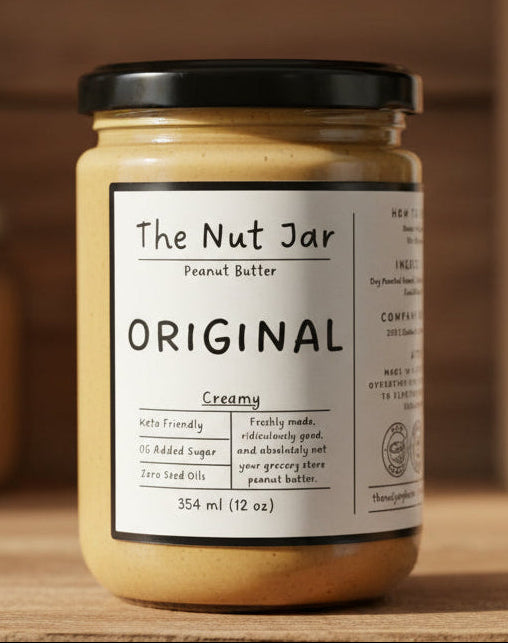 Jar of peanut butter labeled 'The Nut Jar' on a wooden surface with a blurred background

